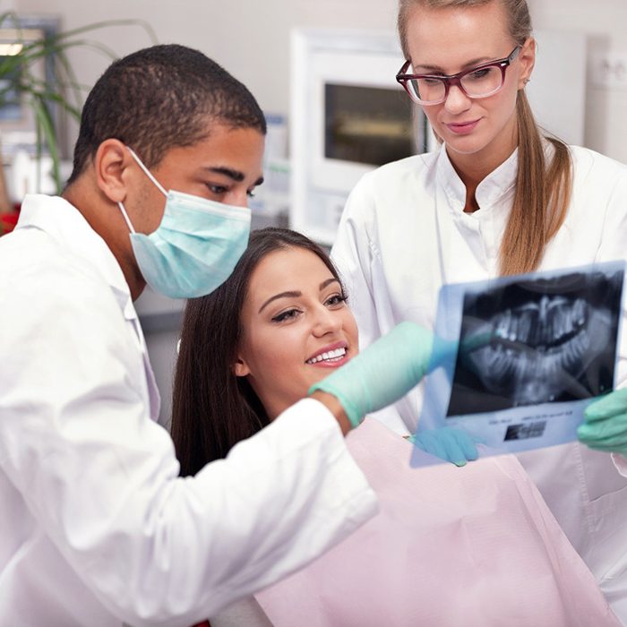 Dentist reviewing X-ray with smiling patient