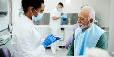 a dentist explaining how dentures work to a patient