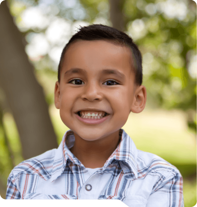 Young boy smiling outdoors after visiting children's dentist in Grand Prairie