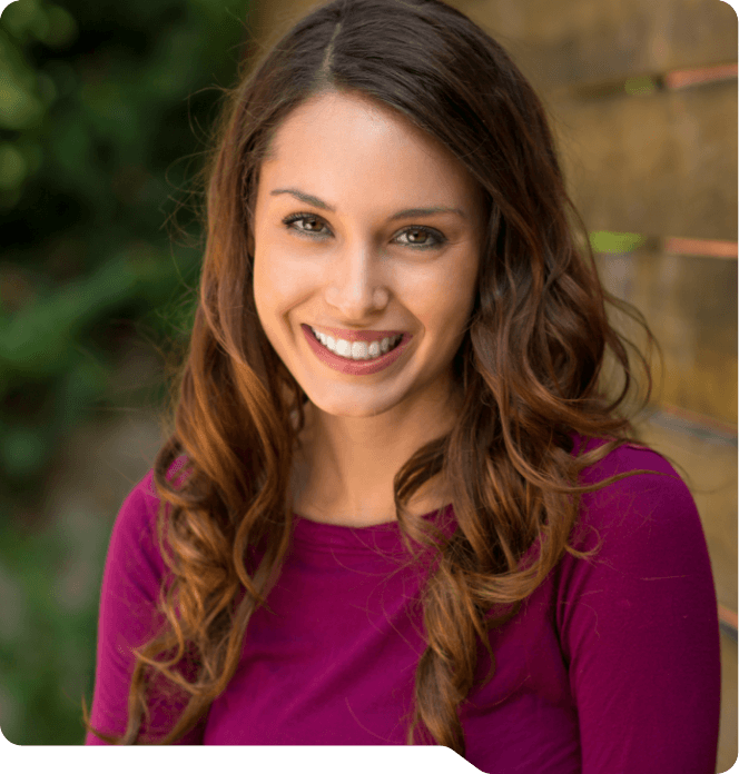 Woman in magenta blouse smiling after cosmetic dentistry in Grand Prairie