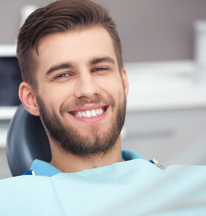 A happy, smiling man sitting in a dentist’s chair