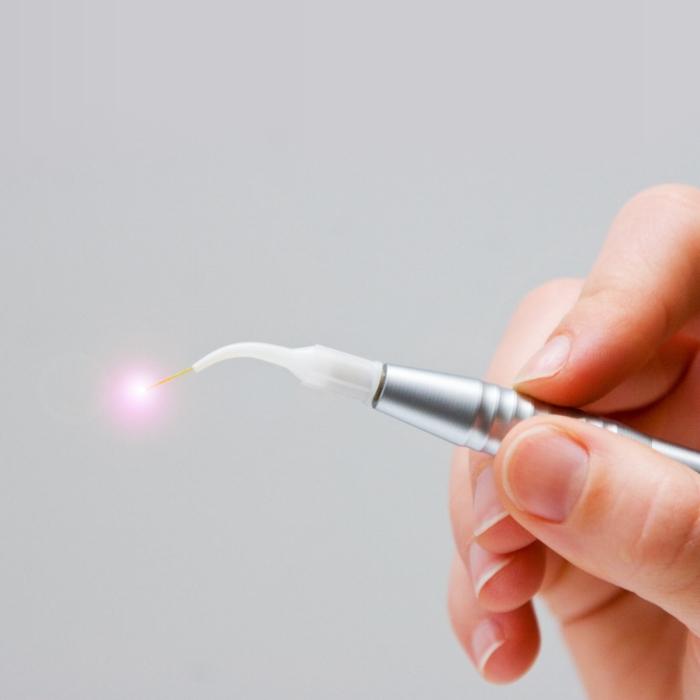 Hand holding a white soft tissue laser