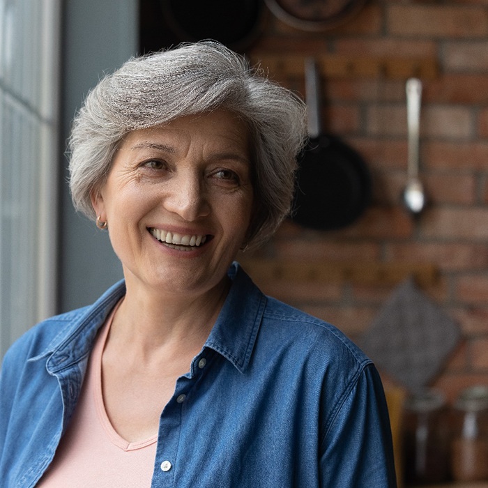 Senior woman smiling by a window