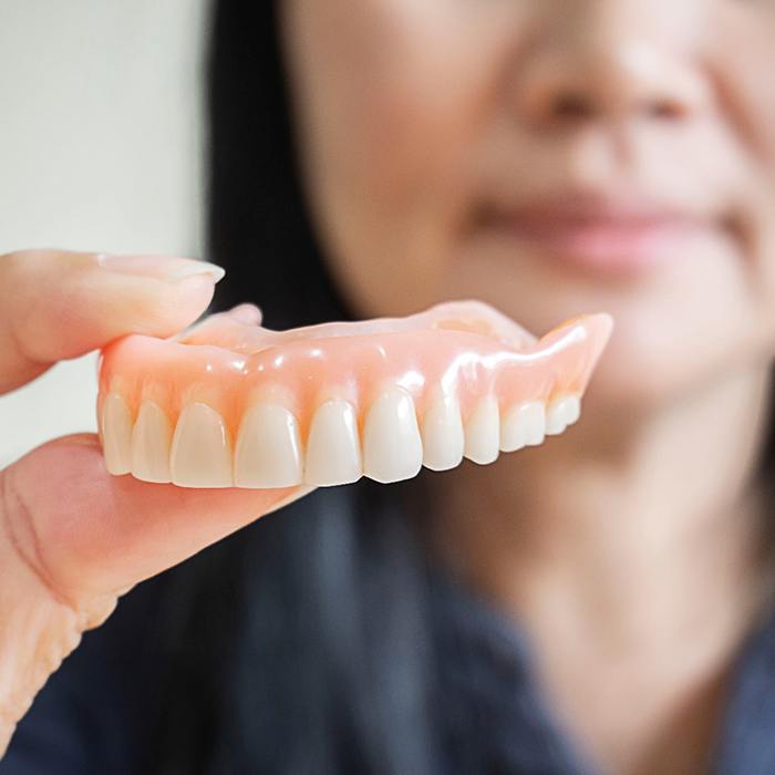 Woman holding a full denture