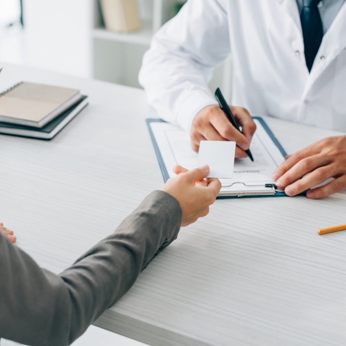 Patient handing their dentist a payment card