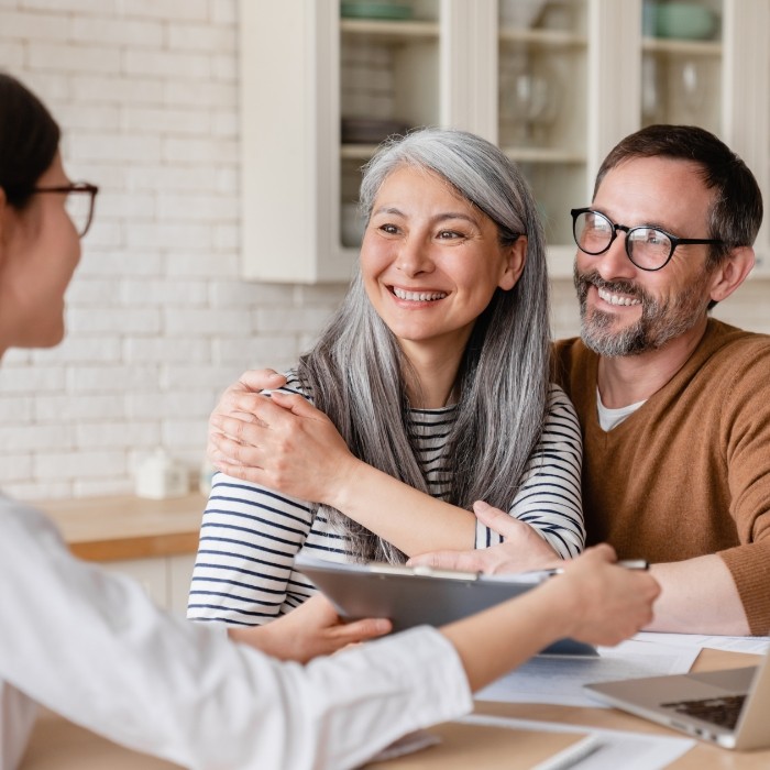 Man and woman talking to dental team member about dental financing