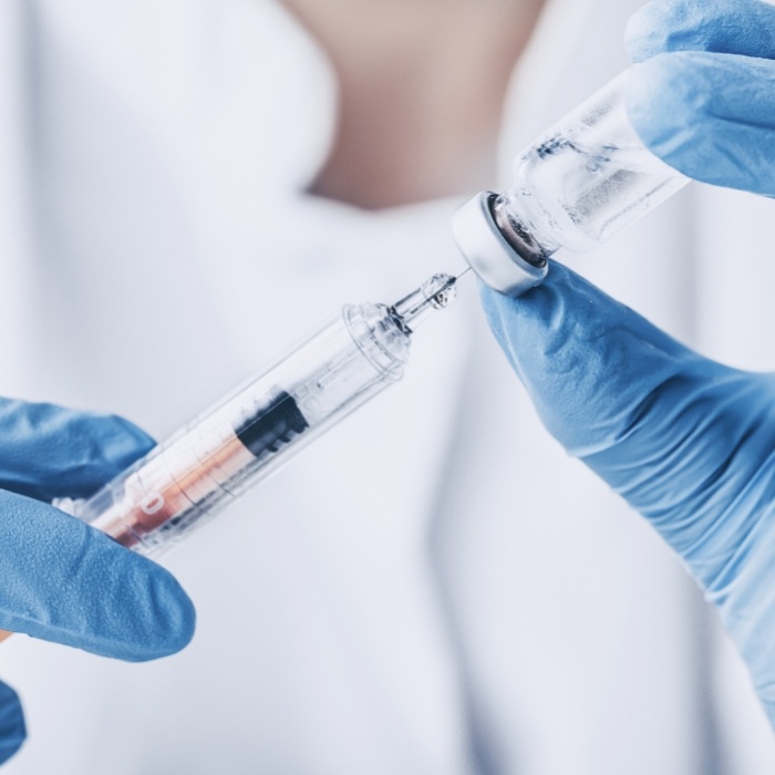 Dentist drawing a syringe with clear liquid