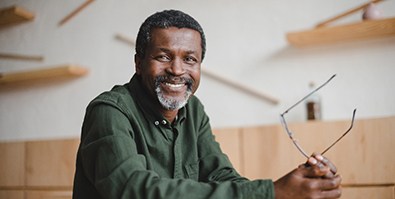 man smiling while sitting at table 