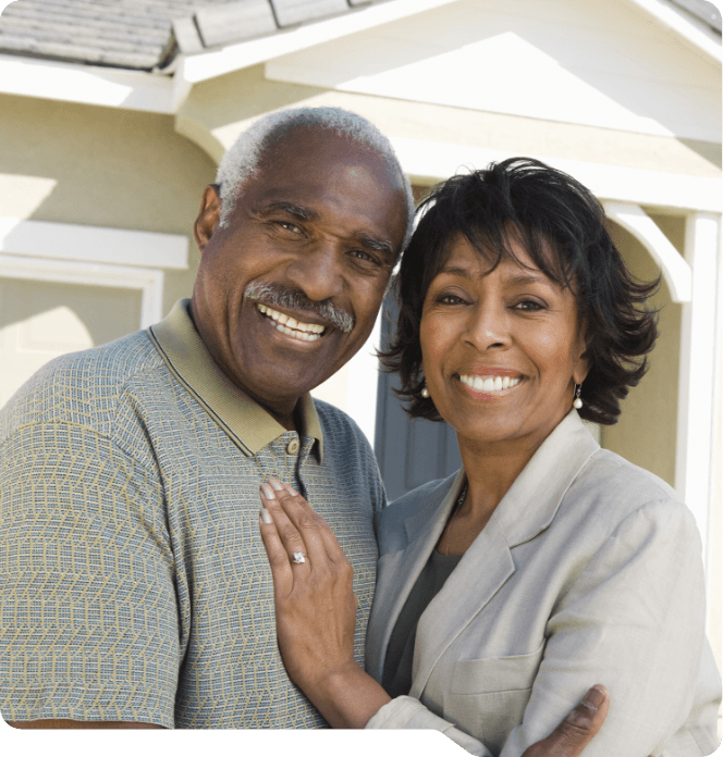 Older man and woman smiling outdoors after replacing missing teeth in Grand Prairie