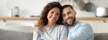 Smiling man and woman sitting at their kitchen table
