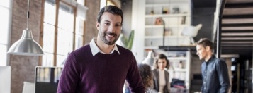 Smiling man standing in open office