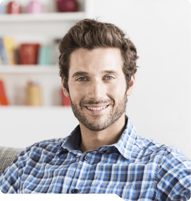 Man in blue plaid shirt smiling after restorative dentistry in Grand Prairie