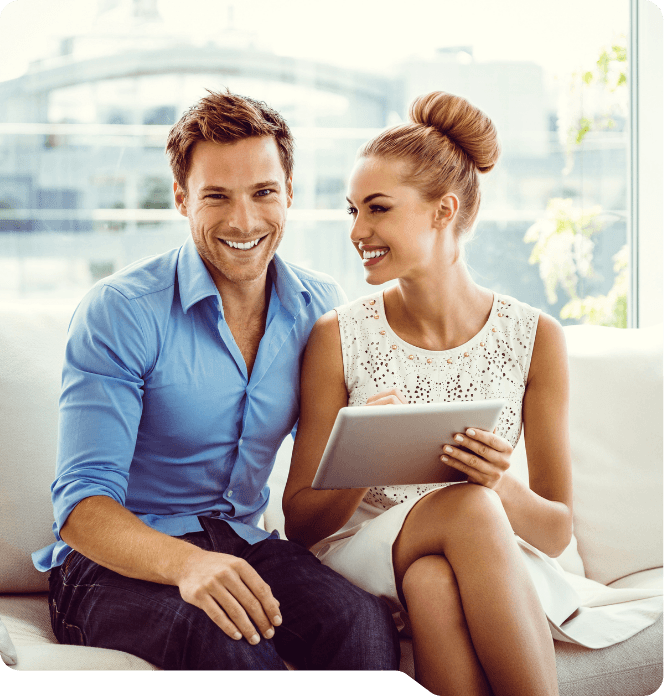Smiling man and woman sitting on couch with tablet