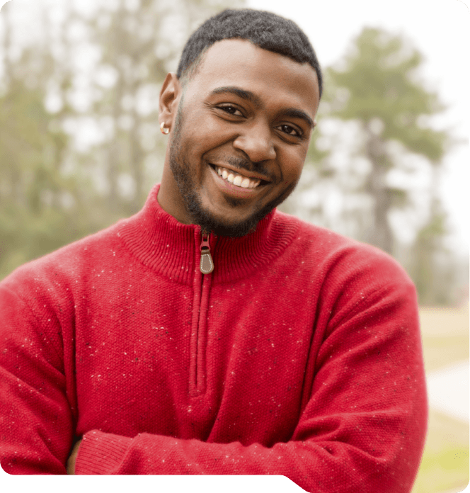 Man in red jacket smiling after root canal treatment in Grand Prairie