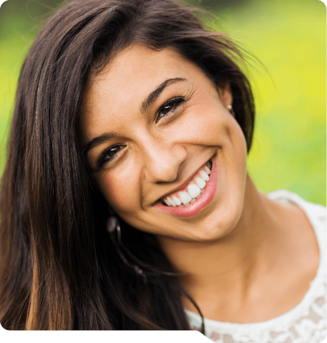 Young woman smiling outdoors after tooth extractions in Grand Prairie